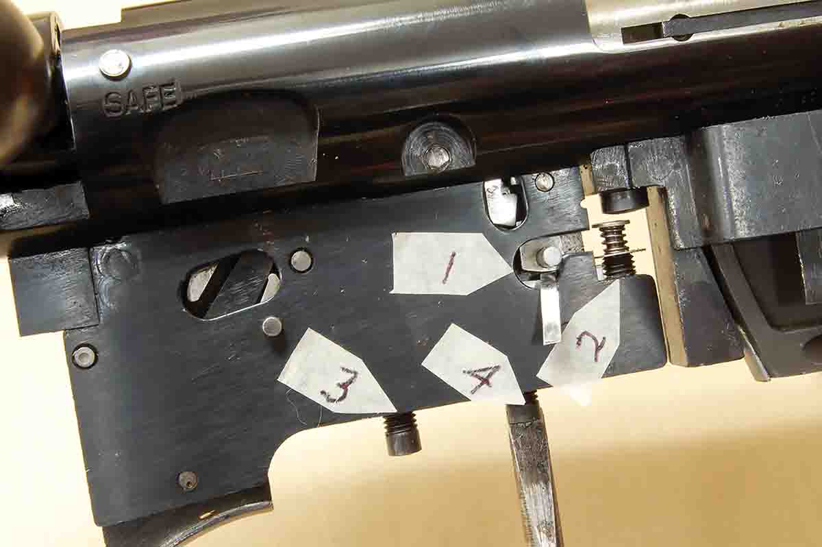 A piece of shim stock is inserted between contact surfaces of the fired lock (1), while the O.T. screw (4) is turned to give .015-inch trigger overtravel. The setting will never be changed.
